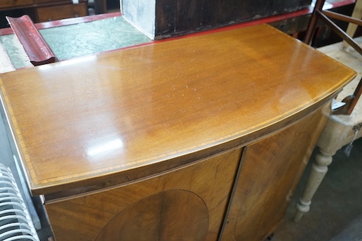 An Edwardian Sheraton revival satinwood banded mahogany bowfront two door side cabinet, width 106cm, depth 53cm, height 95cm